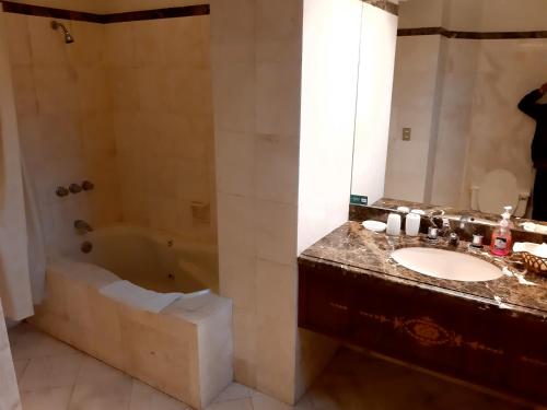 利马Hotel MAURY的一间带水槽和浴缸的浴室