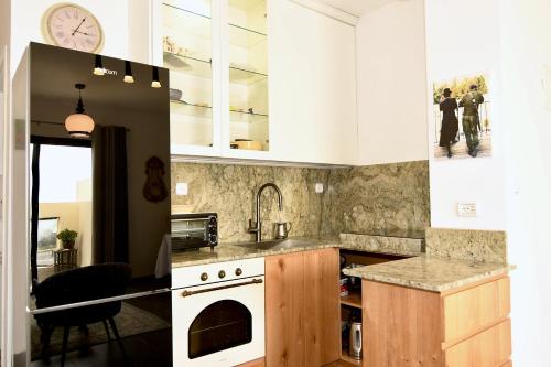 纳哈里亚Hoffman Executive Suites - Beachfront Nahariya的厨房配有白色橱柜和炉灶烤箱。