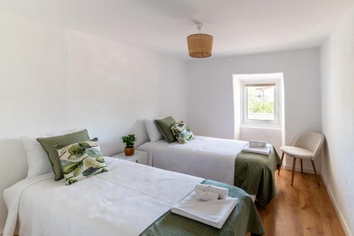 科尔武河畔米兰达Casa das Rosas - Roses House的白色的客房设有两张床和窗户。