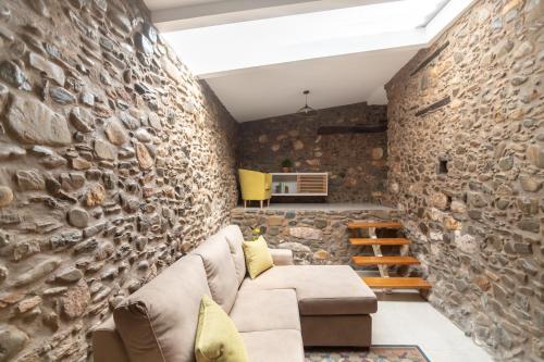科尔武河畔米兰达Casa das Rosas - Roses House的客厅设有石墙和沙发。