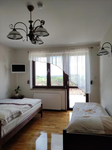 Udryń娜乌兹格祖旅馆的一间卧室设有两张床和大窗户
