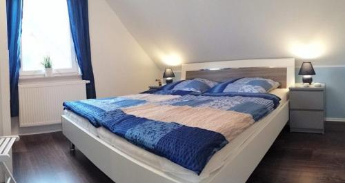 马林费尔德Ferienhaus Strandräuber的一间卧室配有一张大床,提供蓝色的毯子和枕头