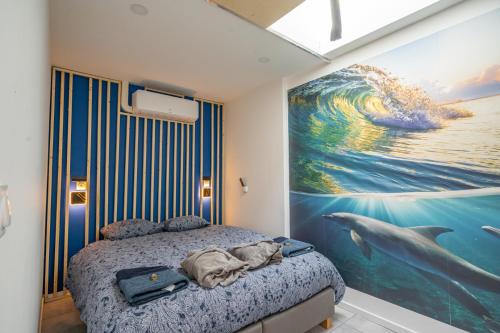 瓦朗西纳Capsule océan - Jacuzzi - Billard - Netflix - 2 Chambres - Cuisine的卧室的墙上挂有海豚绘画
