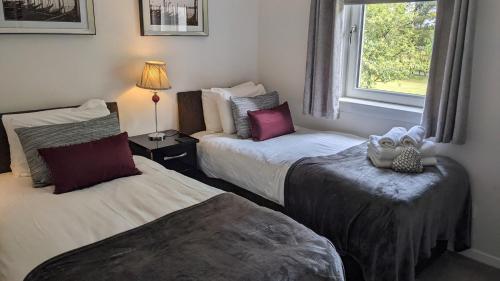 奥赫特拉德Gleneagles Country Apartments的酒店客房设有两张床和窗户。