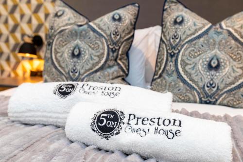东伦敦5th On Preston Guest House的床上的毛巾和枕头