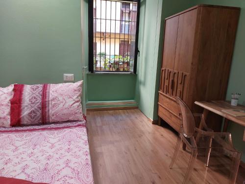 米兰2 Via Fabio Mangone的一间卧室配有一张床、一张桌子和一个窗户。