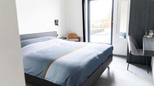 哈瑟尔特B&B Koor91的一间卧室配有一张床、一张书桌和一个窗户。