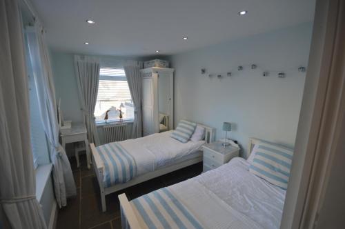 滨海纽比金Sandridge的一间小卧室,配有两张床和窗户