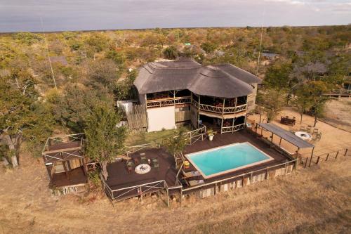 LesomaCHOBE MOPANI FOREST LODGE & CAMP SITE的享有带游泳池的房屋的空中景致