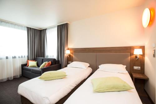 梅斯梅茨中心站钟楼酒店的酒店客房,设有两张床和一张沙发