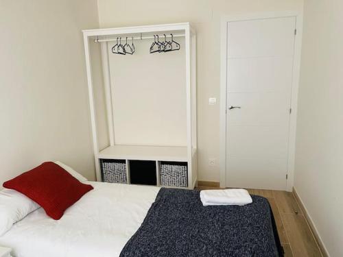 萨拉戈萨PALACIO DE LARRINAGA的卧室配有白色的床和红色枕头