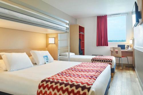 瓦勒德勒伊鲁昂南部勒伊谷基里亚德酒店的酒店客房配有两张床和一张书桌