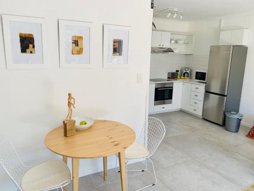 开普敦BEAUTIFUL VIEW Garden Apartment的厨房配有桌椅和冰箱。