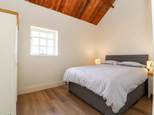 桑德巴奇Swallow Cottage的一间卧室设有一张大床和一个窗户。