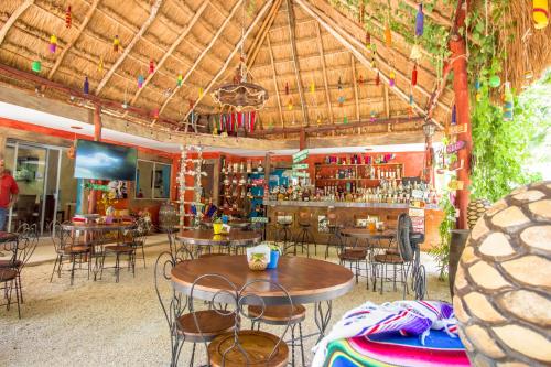 坎昆Hotel Tequila Cancun的一间带桌椅的餐厅和一间酒吧