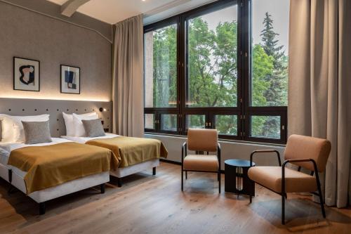 赫尔辛基Scandic Helsinki Hub的酒店客房带一张床、椅子和窗户