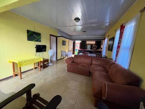 托尔图格罗Casa Artavia的客厅配有棕色沙发和桌子