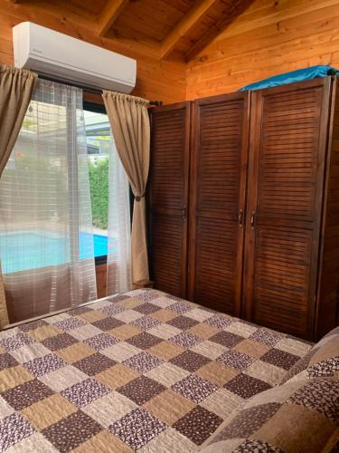 乌维塔Pura Vida Cabinita的一间卧室配有一张带格子床罩的床