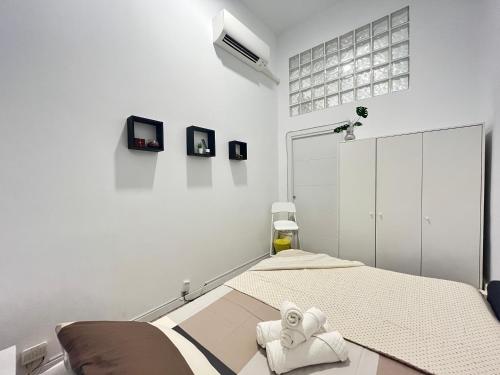 马德里Ile Atocha Exterior Olivar的白色卧室,配有带毛巾的床