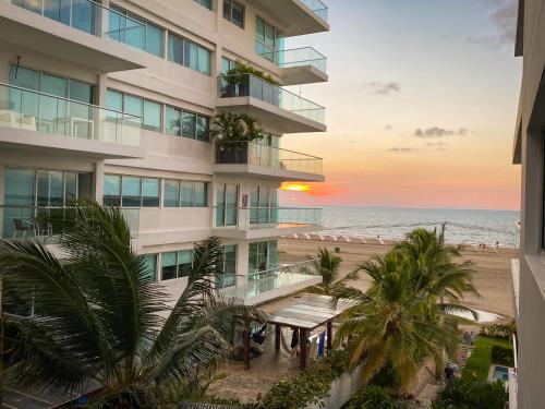 卡塔赫纳Apartamento en Cartagena con vista al mar的公寓大楼俯瞰着日落时的海滩