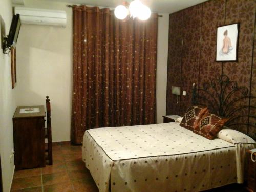 Vega de EspinaredaHostal Piñera的一间卧室配有床和带窗帘的窗户