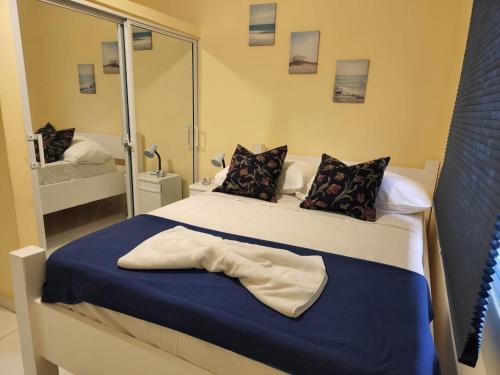 拉罗马纳Apartamentos Melya cerca de la Playa Caleta的一间卧室配有一张带蓝色毯子和镜子的床