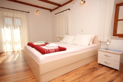 斯拉诺Apartments by the sea Slano, Dubrovnik - 9013的卧室配有白色的床和红色毯子