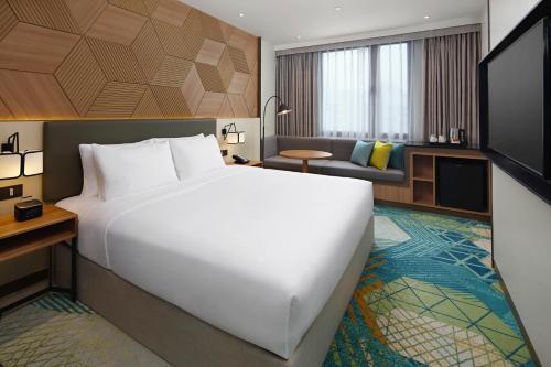 宿务Holiday Inn Cebu City, an IHG Hotel的酒店客房设有一张大床和一张沙发。