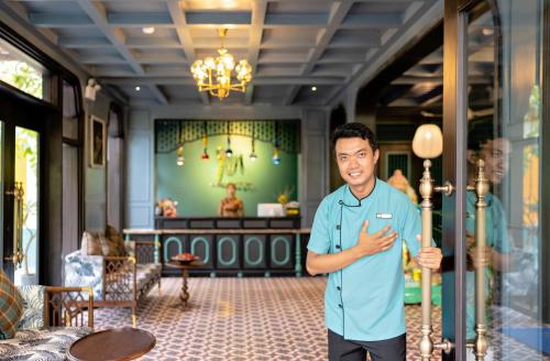 会安Son Hoi An Boutique Hotel & Spa的站在房间前的人