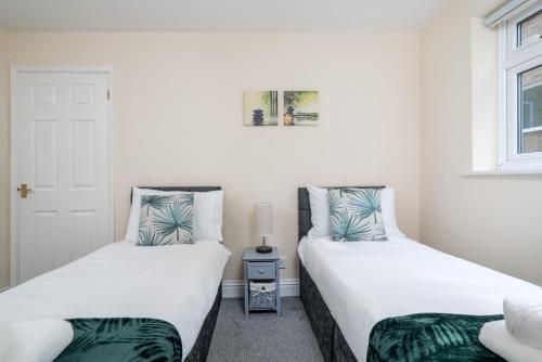 红山Redhill Surrey 2 Bedroom Pet Friendly Apartment by Sublime Stays的两张睡床彼此相邻,位于一个房间里