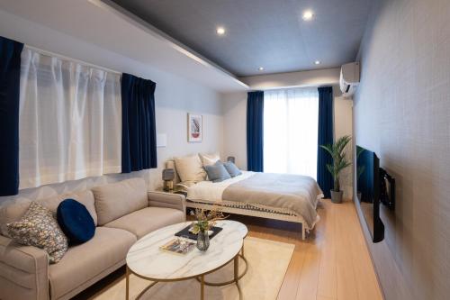 东京Ken's Place麻布East的客厅配有沙发和一张位于房间的床