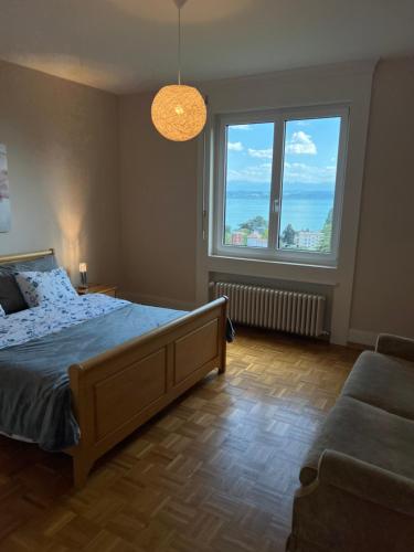 纳沙泰尔Alpes 54的一间卧室设有一张床和两个大窗户