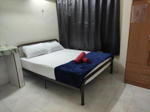 瓜拉丁加奴CiTY Homestay Budget 2bedrooms Midtown Kuala Terengganu的蓝色毯子上一张红色床