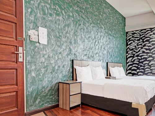 诗巫OYO 89840 69 Room 4 Stay的一间卧室设有两张床和绿色的墙壁