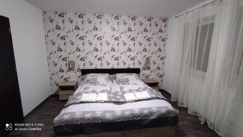 索普隆Lővér Vendégház Sopron的一间卧室配有一张带花卉壁纸的床
