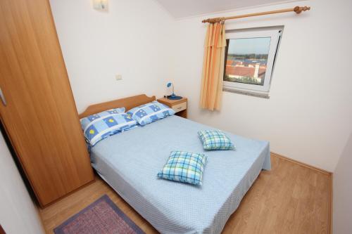 IlovikApartments with WiFi Ilovik, Losinj - 8078的一间卧室配有一张带蓝色枕头和镜子的床