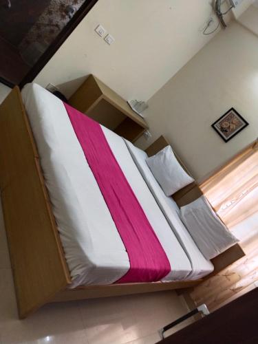 班加罗尔HOTEL SLN Homes的一张大床,上面有粉色和白色的毯子