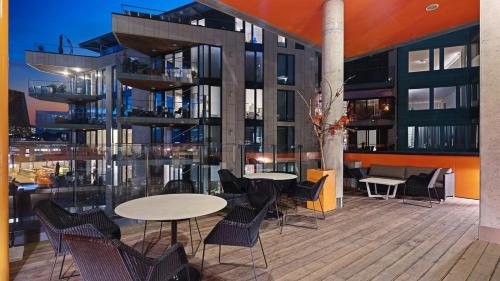 奥斯陆Exclusive apartment, sea view to Oslo fjord, located on water in Oslo center的一个带桌椅的阳台和一座建筑
