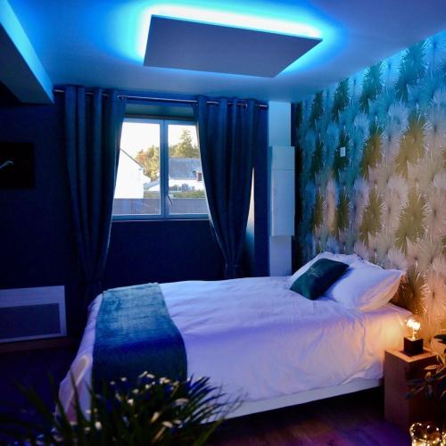 PrinquiauL'Evasion chambre LAOS avec Jacuzzi privatif的一间卧室配有一张蓝色的灯光床