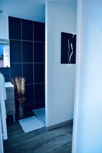 PrinquiauL'Evasion chambre LAOS avec Jacuzzi privatif的浴室设有蓝色瓷砖墙和植物
