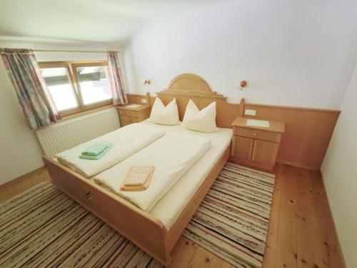 迈尔霍芬Pretty Holiday Home in Mayerhofen with Balcony的一间小卧室,配有一张带白色床单的大床