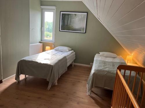 GnosjöBig house, sauna, Wi-Fi, Isaberg, MTB, skiing, golf的一间卧室设有两张床和一个楼梯间