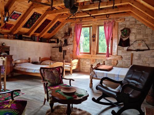 莫伊科瓦茨Ethno Village Štitarica的一间带两张床的卧室和一间带椅子的房间
