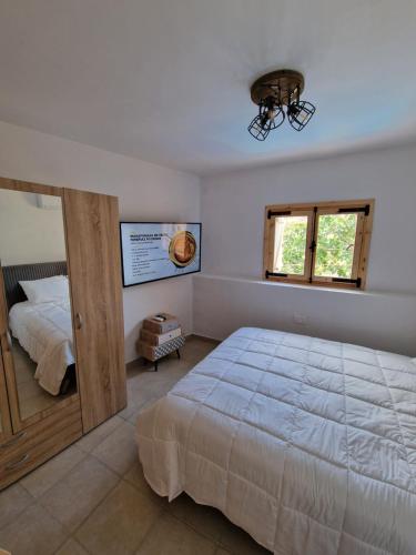 阿格罗斯Aprosmeno Jacuzzi House 3 With Private Pool的一间卧室设有一张大床和一个窗户。