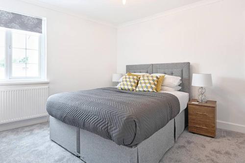 马伯斯3-bed in Mumbles with free parking & sea views的白色卧室配有带枕头的床和窗户