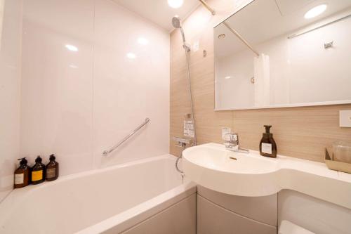 东京Best Western Hotel Fino Tokyo Akasaka的一间带水槽、浴缸和镜子的浴室