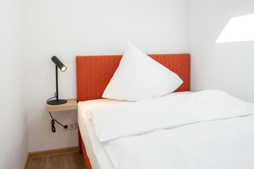 勒讷Suites Lohne的一间卧室配有两张床和床头灯。