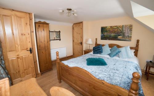 Torpys Cross RoadsBallygown Cottage的一间卧室配有一张带蓝色枕头的木床。