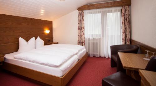 伊施格尔Gasthof Talblick的配有一张床、一张书桌和一扇窗户的酒店客房