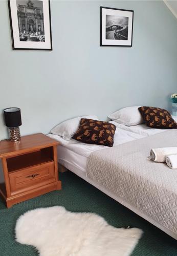 马尔堡ZibiSPA pokój nr 3的配有一张桌子和白色地毯的客房内的两张床